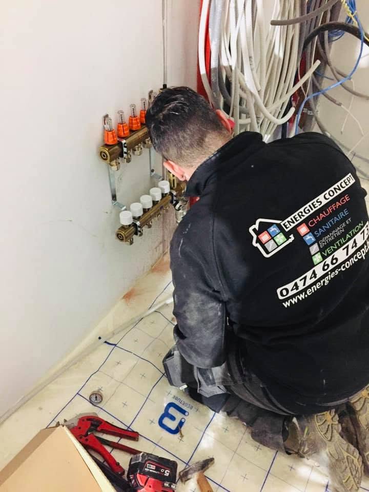 Raccordement d'un collecteur laiton de chauffage par le sol par un technicien Energies Concept à Fleurus