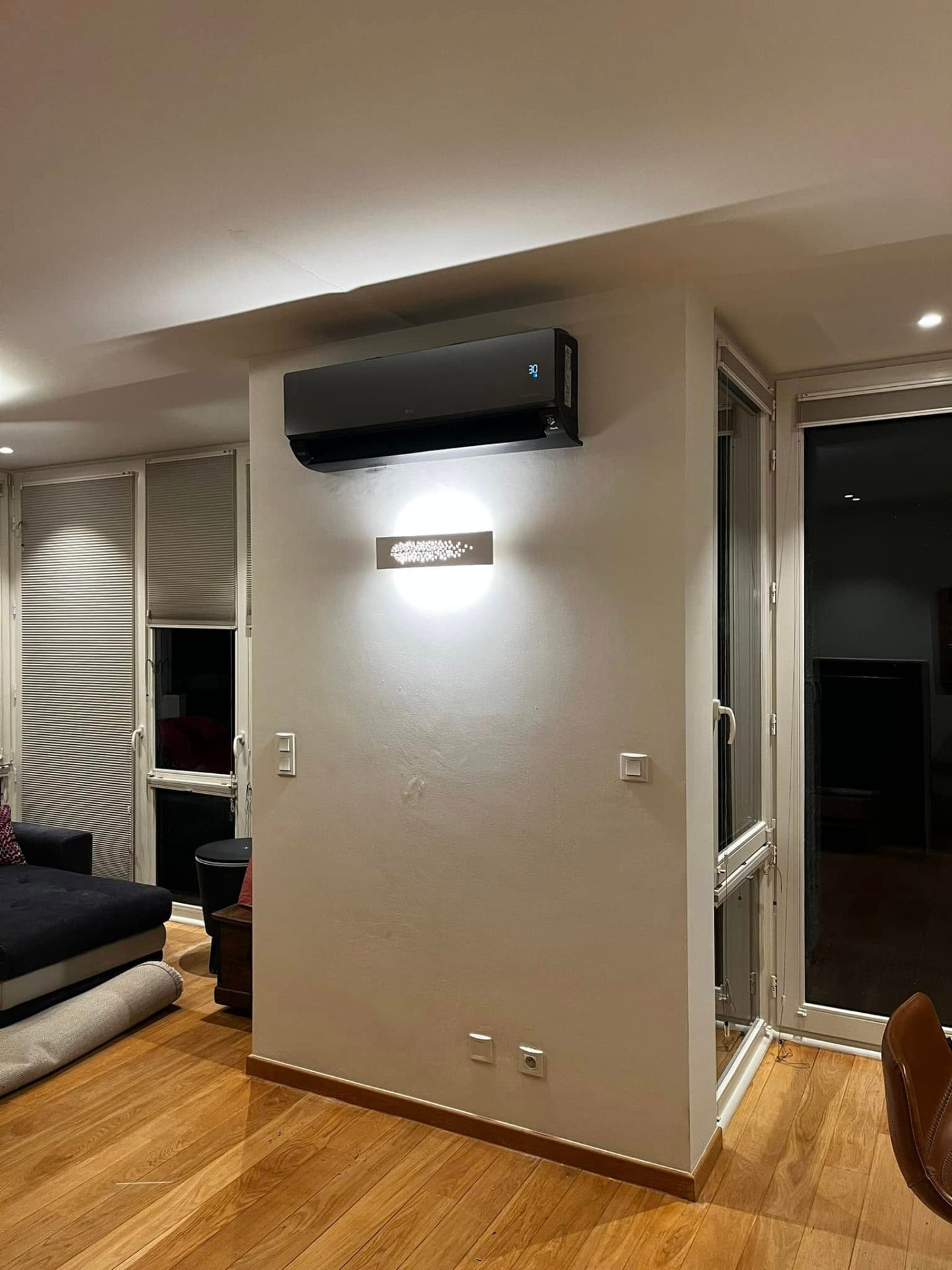 Split de climatisation noir installé dans un salon par Energies Concept à Nivelles