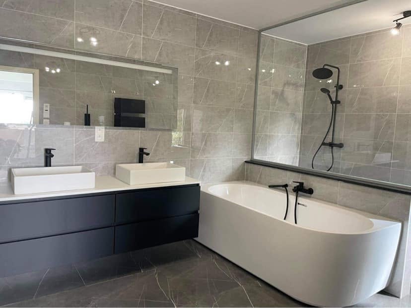 Salle de bain avec double vasque, meuble suspendu et baignoire réalisée par Energies Concept à Nivelles