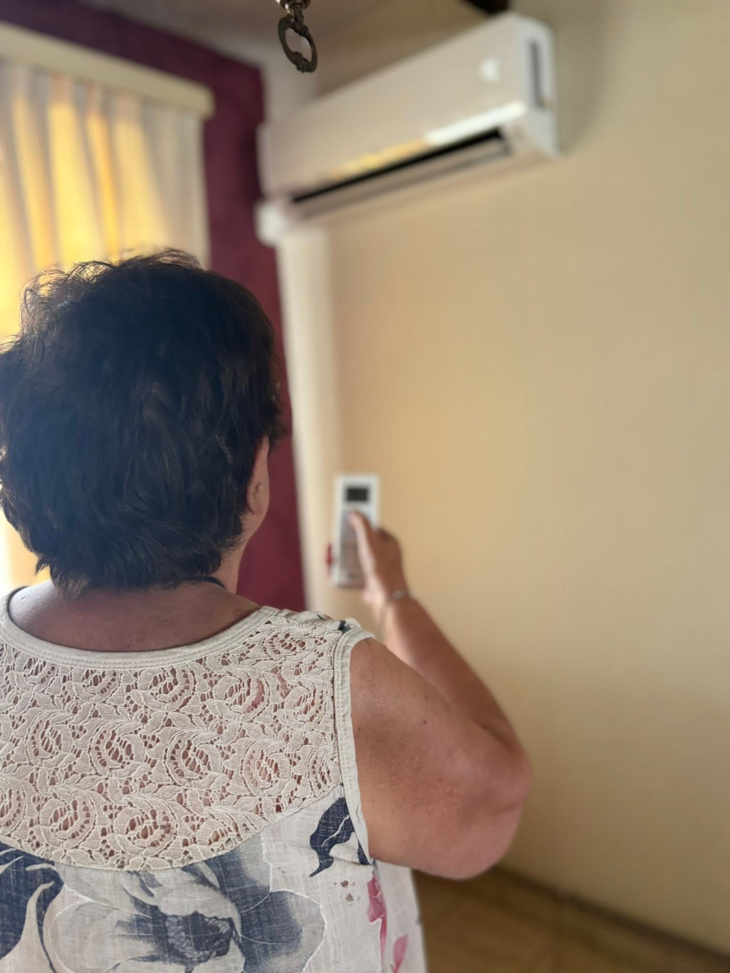 Cliente réglant sa climatisation murale installée par Energies Concept à La Louvière